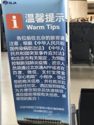 Sign at boarding gate informing passengers that registering with a Beijing health app is mandatory. Sign at boarding gate informing passengers that registering with a Beijing health app is mandatory.